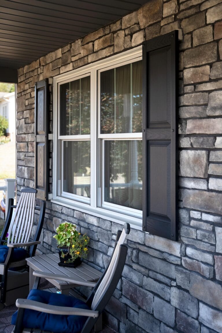ProVia Aeris double-hung window with shutters on a stone porch